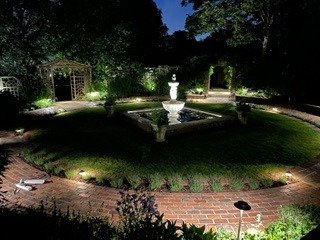 Exterior lighting scheme illuminating a formal garden at night